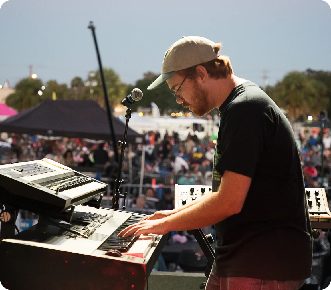 Musician playing keyboard at outdoor concert
